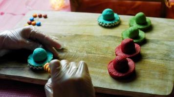 je dessine des lignes avec du glaçage sur des biscuits sombrero mexicains en trois couleurs video