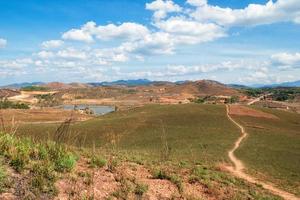 Rural landscape with mountains, fields, village and lake on background of blue cloudy sky. Phonsovan, Laos. photo