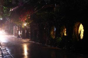 View on a night street of city with lantern and moving transport in a rainy weather. Long exposure. Chiang Mai, Thailand. photo