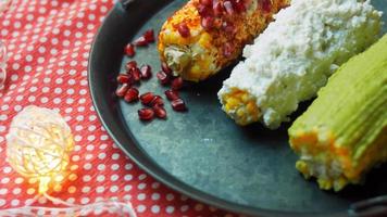 Mexicaans maïs Elote in drie manieren. ingedrukt met kaas, guacamole en granaatappel. maxicaans vlag video