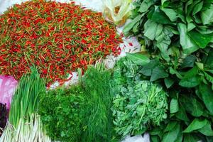 Fresh chili peppers and greens on street market. Traditional local morning market in Luang Prabang, Laos. photo