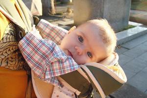 Cute little girl in ergo carrier on a walk with her father. photo