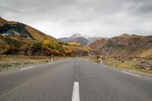 Empty road between Caucasus Mountains in autumn time. photo