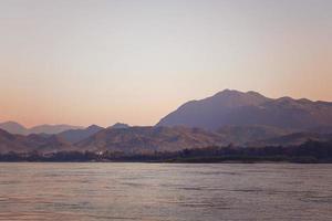 paisaje tropical con río y montañas al atardecer. río mekong, luang prabang, laos. foto