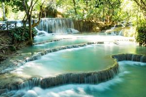 Scenic view on Kuang Si waterfall with turquoise water on a sunny day. Luangprabang, Laos. photo