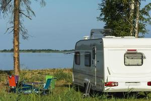 Camper trailer in nature on the background of the lake, tourism, travel, outdoor recreation, active lifestyle photo