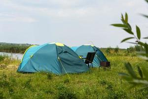 carpas turísticas para acampar en la orilla del lago, historia de viajes. pesca, turismo, recreación activa. paisaje natural. para el diseño de estilo de vida. recreación al aire libre foto