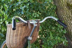 stylish green vintage retro bike with wicker basket , bicycle handlebar, wicker basket photo