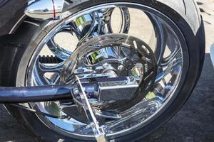 motorcycle brake disc on the rear wheel, brake caliper and tire, shining chrome photo