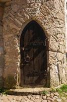 puerta de madera antigua medieval de la antigua torre, bisagras ásperas de hierro, textura áspera foto