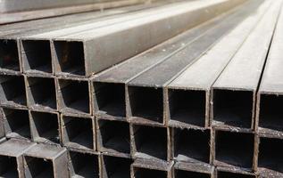 metal square profile in a stack, metal pipes of square cross-section on the site of a building materials store, metal building materials photo