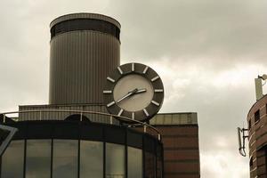 A large street clock with hands hanging over the entrance to the station building photo