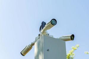 Security cameras and a Wi-Fi station installed on a pole in a public place. Surveillance and security technologies. photo