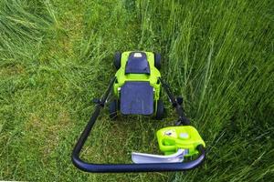 Lawn mower on the grass, lawn care, mowing the grass, country cares, lawn mowing with an electric lawn mower photo