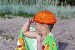 un niño en la playa de panamá y con una toalla, se limpia del agua del mar después de nadar en el mar foto