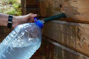 collecting natural spring water in a 5-liter plastic bottle, filling the bottle with fresh clean drinking water