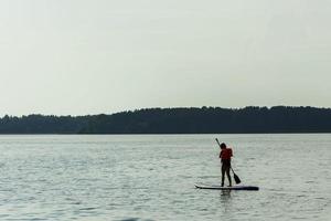 A young mother swims on a standing paddle board . SUP board. Water sports photo