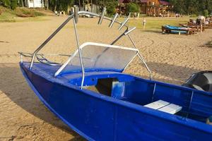 barco de pesca azul de aluminio con motor cerca de la orilla del lago, pesca, turismo, recreación activa, estilo de vida. foto