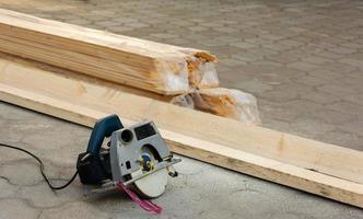 small circular saw and boards on the construction site, sawing boards with power tools, construction, repair photo