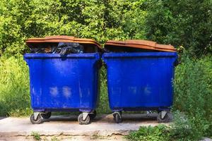 botes de basura de la calle, basura desbordante de grandes botes de basura sobre ruedas para basura, reciclaje foto