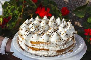 delicious festive sponge cake decorated with white air cream, birthday cake, delicacy photo