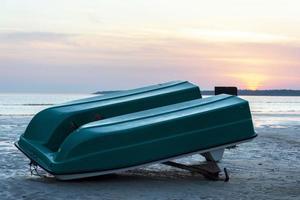 un viejo bote de plástico invertido en la orilla de la bahía del mar, un viejo catamarán, una hélice