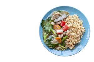 Top view of Fried noodle with pork, chinese kale and carrot thai call Rad Na in blue plate isolated on white background. photo