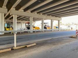 Construction industrial work under the bridge and large highway overpass with the help of modern construction equipment such as asphalt rollers photo