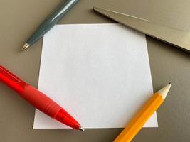 Small square pieces of paper for notes and notes on the office desk and ballpoint pens with pencils. Business work photo