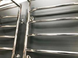 bright, metal heated towel rail for drying towels and linen in the bathroom. curved arms for drying the room. laundry room with equipment photo