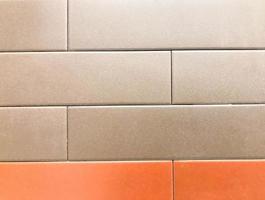 decorative brick for wall covering, texture. white brick tiles, bath and shower covering. slippery, smooth marble surface. at the bottom a strip of tiles of bright orange color photo