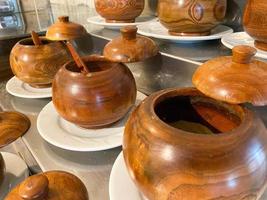 Small round wooden pots with spoons of spices and seasonings in a cafe or canteen photo