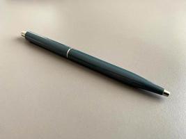 Automatic green ballpoint pen for writing on your desktop office desk. Business work photo