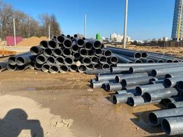 grandes tuberías de plomería de plástico negro industrial de polipropileno moderno de gran diámetro en el sitio de construcción en la colocación de tuberías de agua y la construcción y renovación de edificios y casas foto