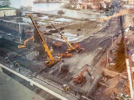 construction of a bridge in the city center. construction of a new overpass on a fenced section of the road. view from a height of a large construction site photo