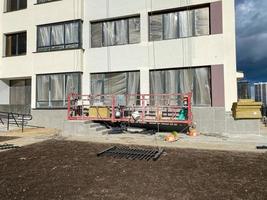 Construction cradle is a hoist for lifting to a great height when carrying out repairs and construction of a building or a new house on a new construction site photo