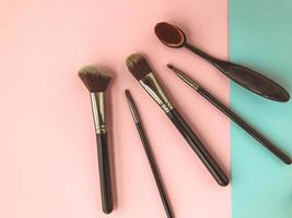 brushes lie on a bright background pink-blue background. brushes for makeup, skin, eyeshadows and eyelids. beauty with liquid and powdery textures photo