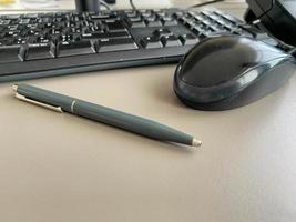 Automatic green ballpoint pen for writing on desktop office desk with computer keyboard and mouse. Business work photo