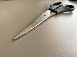 Black metal sharp scissors for paper on the working office table. Business work photo