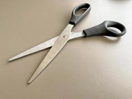 Black metal sharp scissors for paper on the working office table. Business work photo