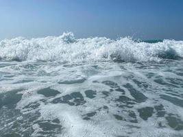 Beautiful sea with waves splashing warm sparkling clear blue water in a warm tropical oriental country southern resort. Background, texture photo