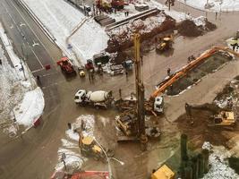 construcción de un puente en el centro de la ciudad. equipos de construcción, máquinas para mezclar hormigón y hacer asfalto. construcción de grandes estructuras de hormigón foto