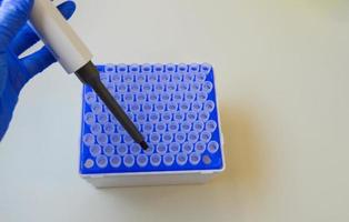 A scientist in a medical laboratory with a dispenser in his hands is doing an analysis photo