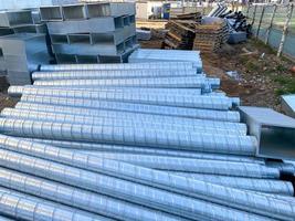 Shiny metal industrial stainless steel pipes for ventilation on a construction site photo