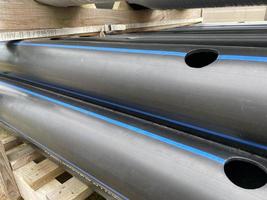 Large plastic pipes of large diameter with flanges in an open-air storage warehouse for the storage of materials and industrial equipment photo