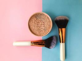 loose powder on a bright background. next to the powder are two fluffy brushes for the face and skin. pink face powder, matte skin photo