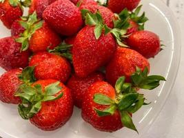 Red beautiful sweet tasty healthy berry ripe vitamin strawberry on a plate as a dessert or snack photo