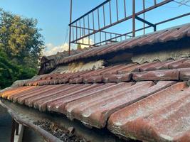 Red ceramic tiles on the roof of the house vintage natural ancient old beautiful, close view. Natural classical building materials for the roof photo