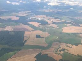 formas geométricas abstractas de parcelas agrícolas de diferentes cultivos en colores amarillo y verde. toma de vista aérea desde un dron directamente sobre el campo foto