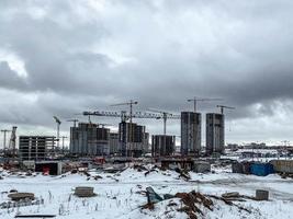 construction of houses, a shopping center from concrete blocks in the city. construction of a new residential area in the winter on the outskirts of the city. block of high-rise buildings photo